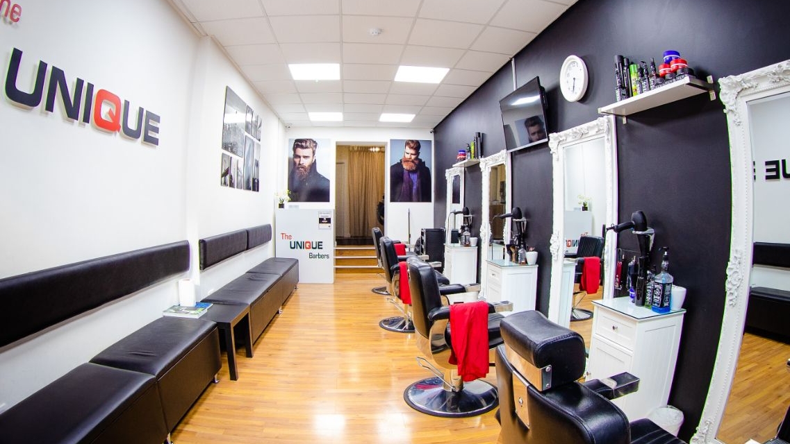 Inside The Unique Barbers, with black barber chairs and white framed mirrors