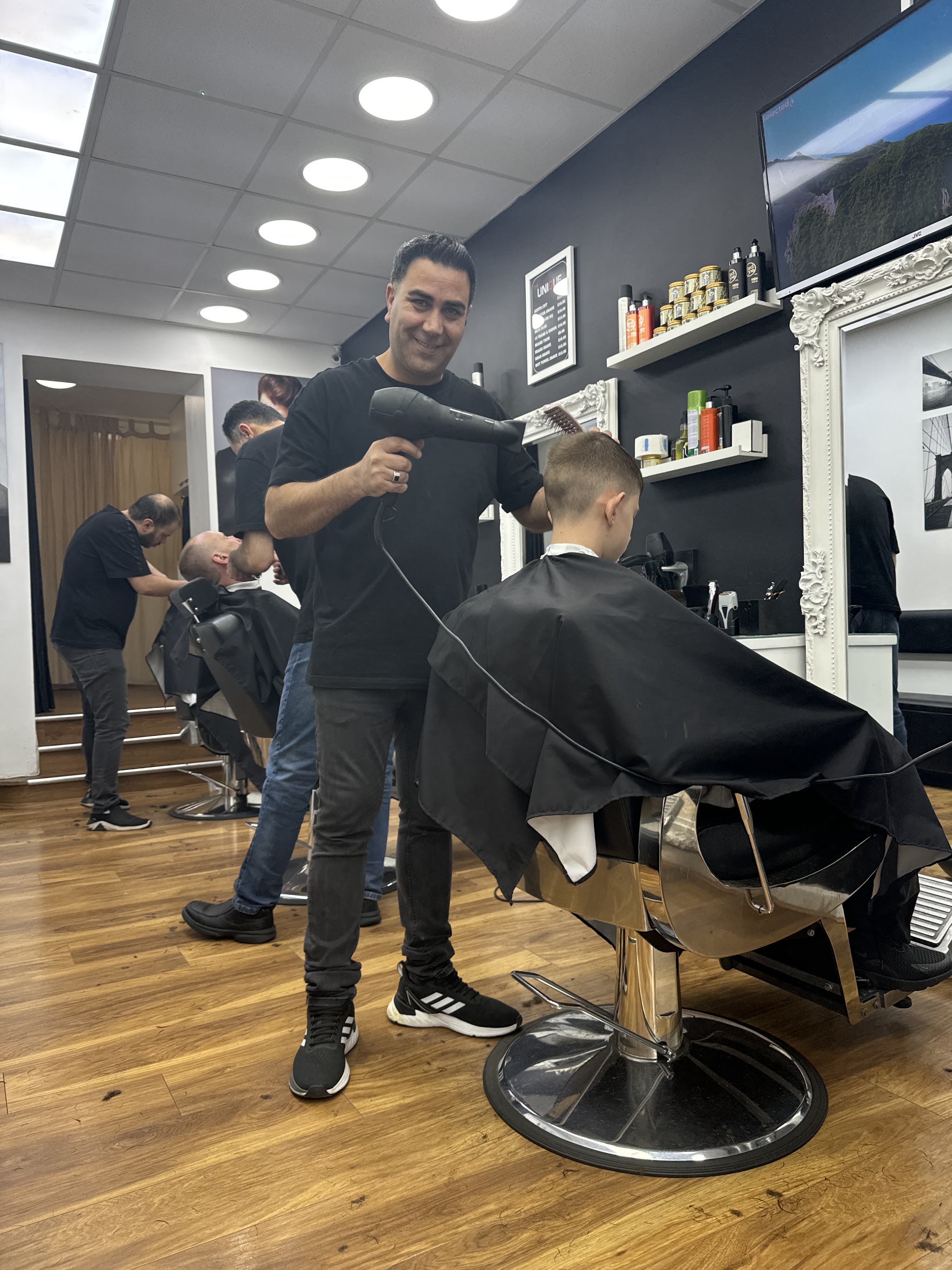 A barber drying a customer's hair in the Brook Street shop
