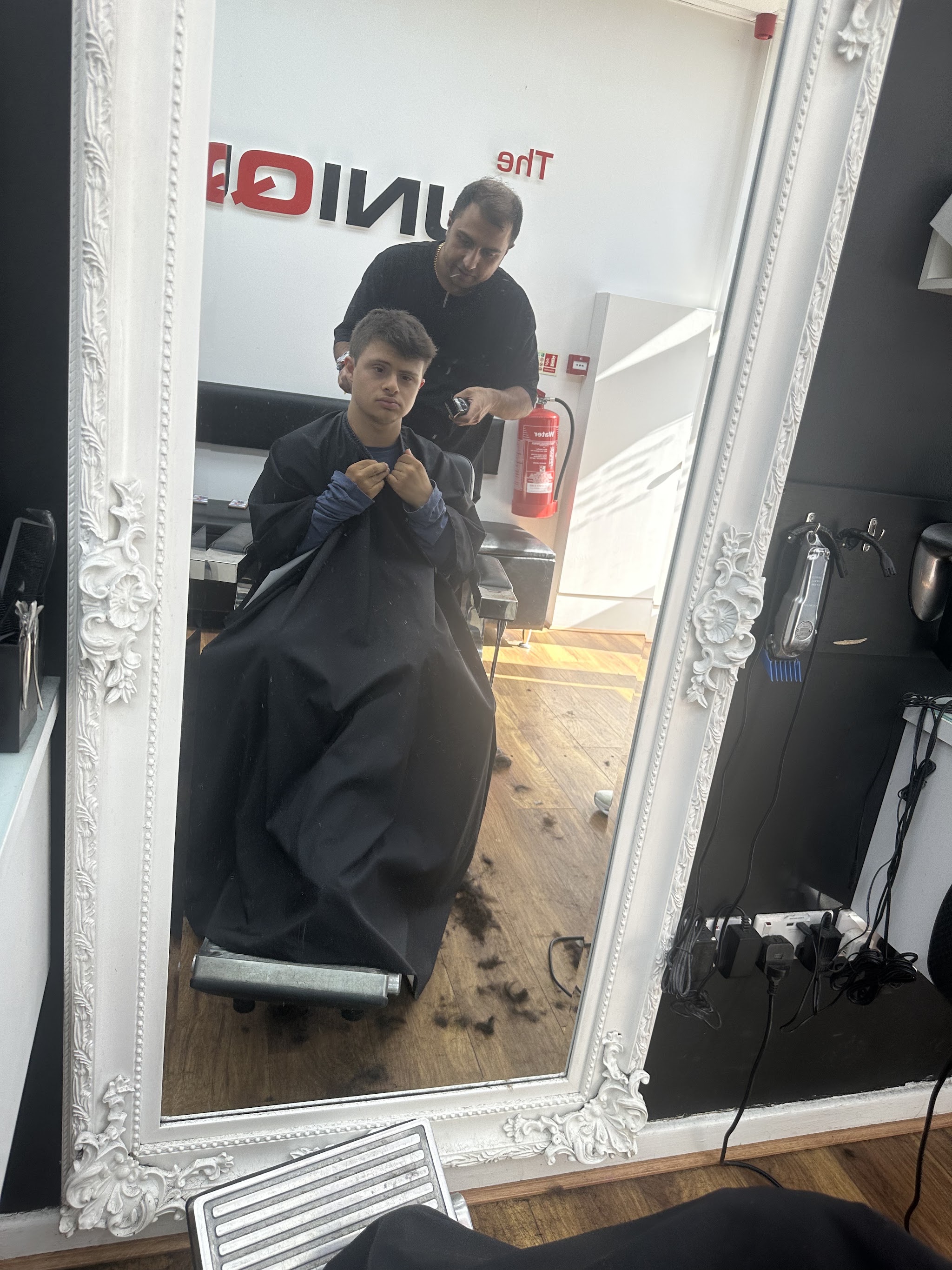 A haircut reflected in one of the shop's white framed mirrors