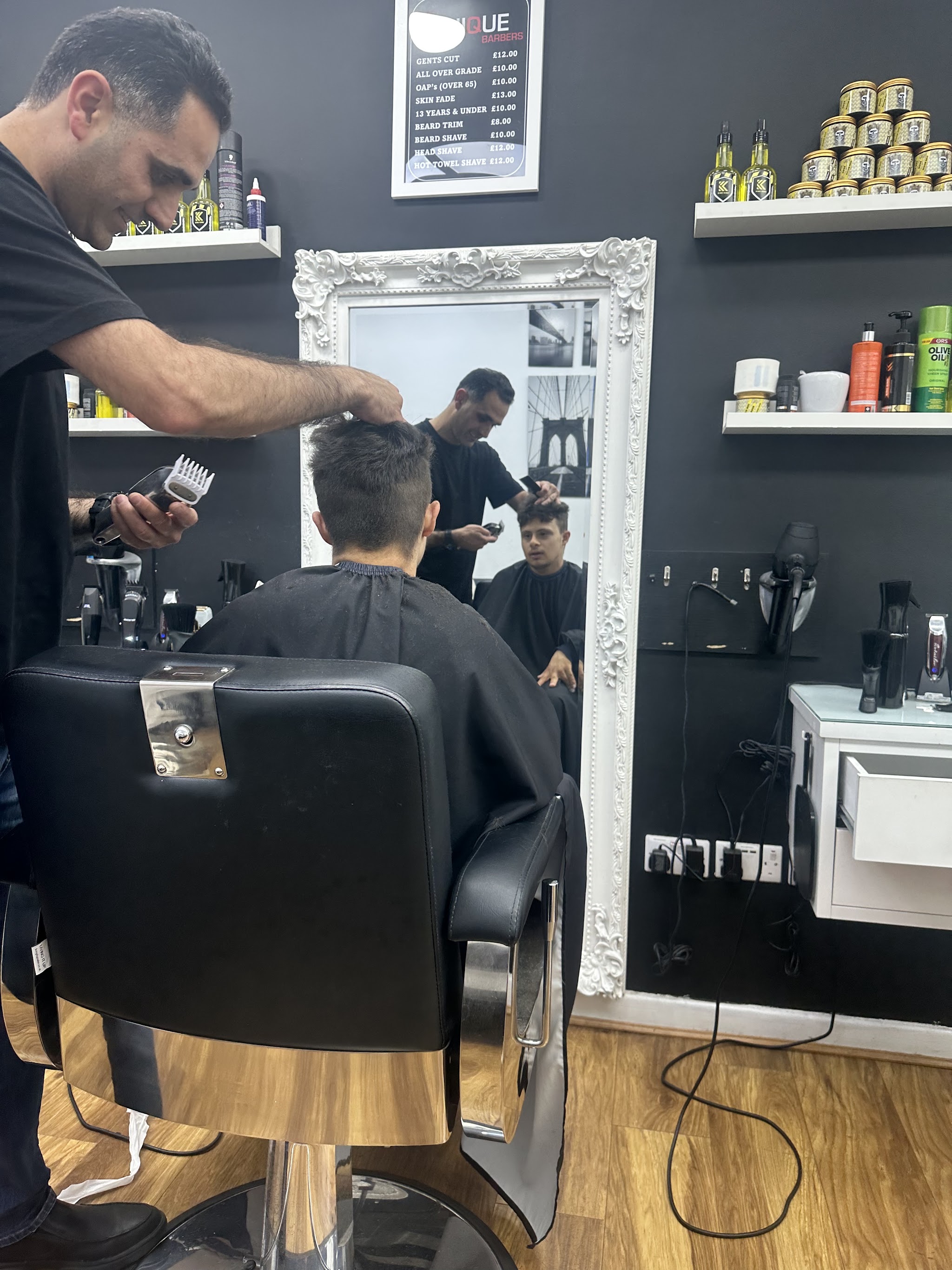 A barber finishing the back of a customer's haircut
